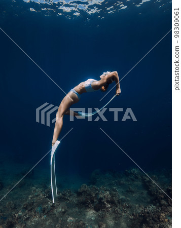Professional freediver fun underwater in blue ocean 98309061