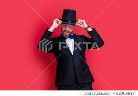 man magician wear tuxedo having fun in studio. magician man wearing cylinder hat. man magician man magician wear tuxedo having fun in studio. magician man wearing cylinder hat. man magician 98309617
