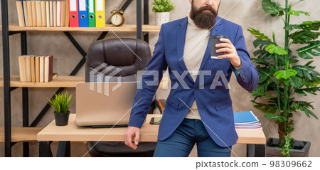 Professional guy crop view drinking tea or coffee sitting on office desk, break 98309662