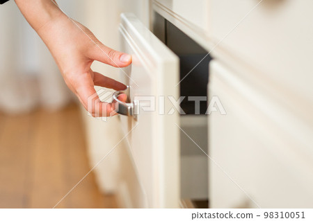 Close-up on woman's hand opens kitchen table drawer 98310051