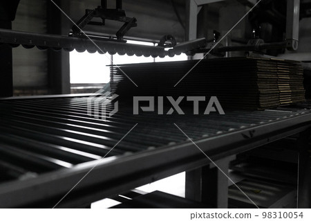 Close-up on the conveyor for the creation of boxes for packaging from recycled paper Close-up on the conveyor for the creation of boxes for packaging from recycled paper 98310054