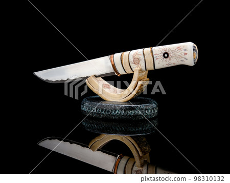 souvenir collectible silver gold dagger cutlass with scabbard, with metal engraving, Bone handle on black. Luxury weapons with traditional patterns in medieval vintage viking shamanic style souvenir collectible silver gold dagger cutlass with scabbard, with metal engraving, Bone handle on black. Luxury weapons with traditional patterns in medieval vintage viking shamanic style 98310132