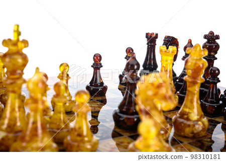Natural amber different chess pieces figures standing on brown stone board. Close up game concept competition, Classic Gambit Tournament of confrontation. Natural amber different chess pieces figures standing on brown stone board. Close up game concept competition, Classic Gambit Tournament of confrontation. 98310181