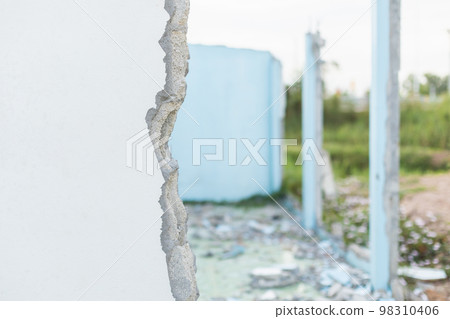 Broken cement wall in process of break house on blur Broken cement wall in process of break house on blur 98310406