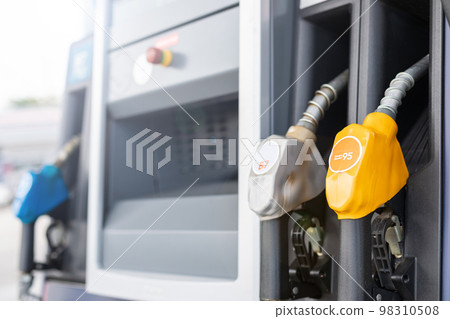 Fuel nozzle in Petrol station. Soft focus on blur day light background with space for text. Energy or transportation concept 98310508