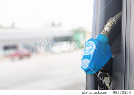 Fuel nozzle in Petrol station. Soft focus on blur day light background with space for text. Energy or transportation concept 98310509