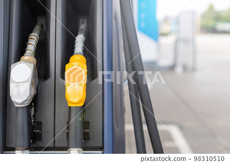 Fuel nozzle in Petrol station. Soft focus on blur day light background with space for text. Energy or transportation concept 98310510