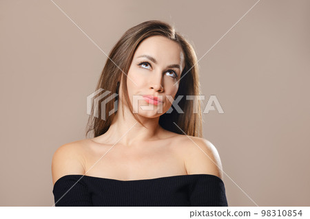 Studio portrait of sceptical woman pursing her lips Studio portrait of sceptical woman pursing her lips 98310854