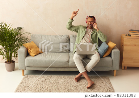 Headphones Man Listening Music. Cheerful Guy Using Laptop At Home 98311398