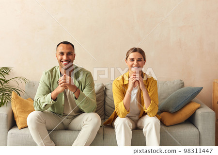 Happy Couple Watching TV At Home. Loving People Resting On Sofa 98311447
