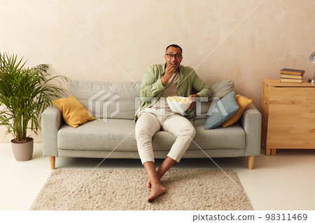 Emotional Man Watching Movie. Multiracial Guy Eating Popcorn, Feeling Scary 98311469