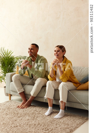 Happy Couple Watching TV At Home. Loving People Resting On Sofa 98311482