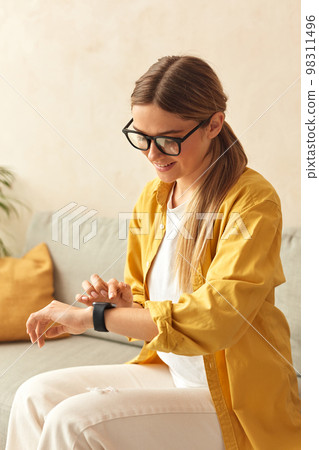 Smiling Woman Using Smart Watch. Caucasian Girl Touching Wrist Watch 98311496
