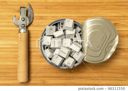 Can opener and tin can full of computer keyboard keys 98311550