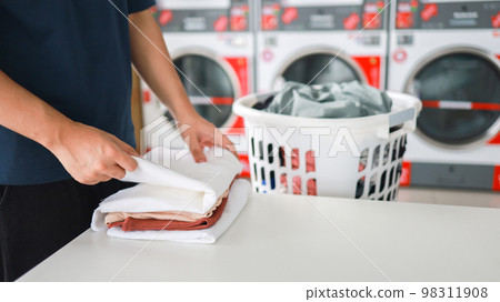 Man doing launder holding basket with dirty laundry of the washing machine in the public store. laundry clothes concept 98311908