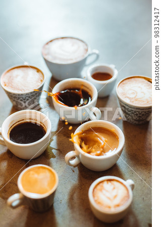 Vertical view of the many cups of coffee standing on stone table 98312417
