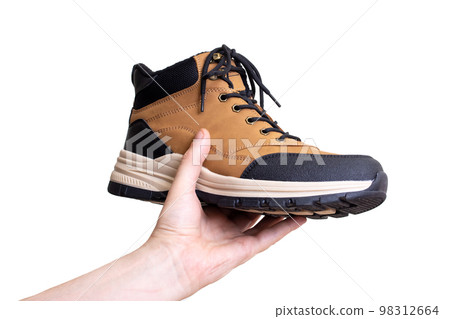 Brown boot in hand on white background 98312664
