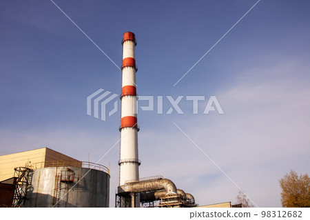 Red and white pipe of plant against background of blue sky Red and white pipe of plant against background of blue sky 98312682