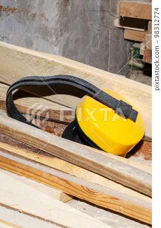 Protective headphones lie on wooden boards closeup 98312774