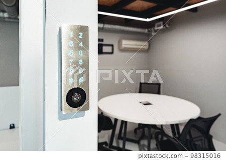 Electronic digital door lock on white office wall 98315016