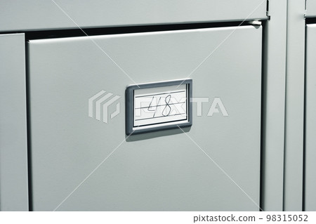 Gray file cabinet with document files in office 98315052