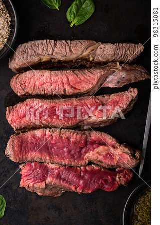 Different degrees of steak roasting. Steak with blood, medium to high roast steak on a wooden board 98315081
