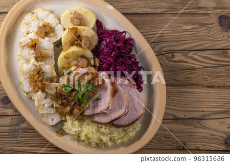 smoked meat served with red and white cabbage and two kinds of dumplings smoked meat served with red and white cabbage and two kinds of dumplings 98315686