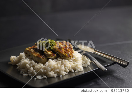 grilled poultry meat with pesto served with rice 98315780