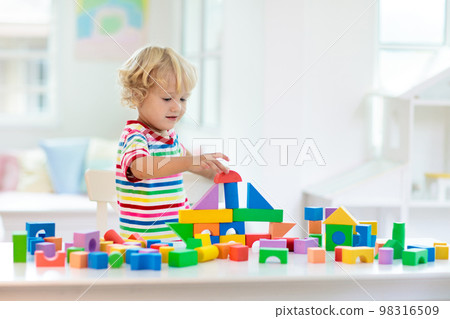 Kids toys. Child building tower of toy blocks. Kids toys. Child building tower of toy blocks. 98316509