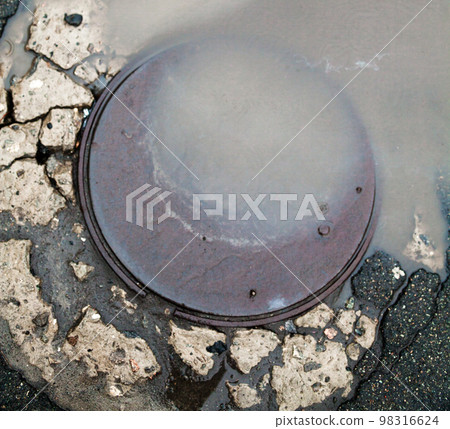 Manhole. The puddle on the manhole. Manhole. The puddle on the manhole. 98316624