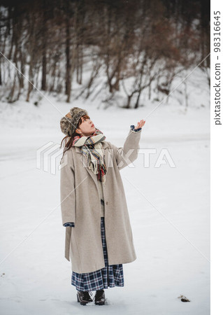 A woman enjoying innocently in a snowy winter landscape 98316645