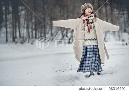 A woman enjoying innocently in a snowy winter landscape 98316691