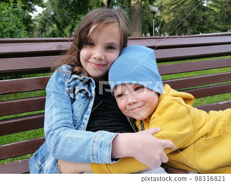 Portrait of adorable brother and sister smile and laugh together while sitting outdoors. happy lifestyle kids. High quality photo 98316821