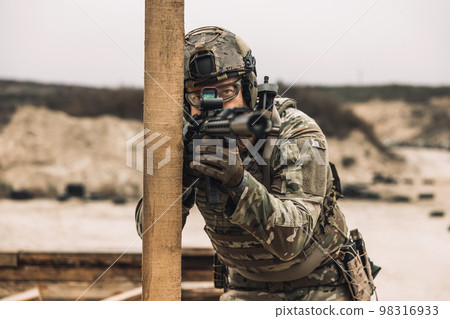 Bearded sniper with optical rifle shooting 98316933