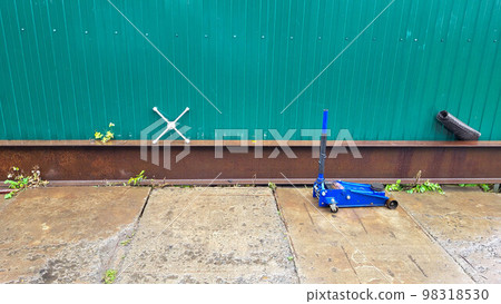 Auto repair shop tire repair tools are lying near the green fence Auto repair shop tire repair tools are lying near the green fence 98318530