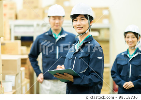 A field worker wearing a helmet for warehouse management A field worker wearing a helmet for warehouse management 98318736