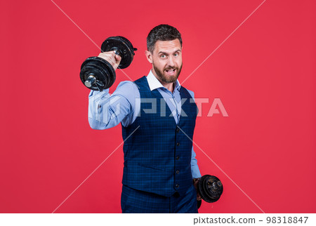 Strong man businessman do dumbbell workout red background, business strength 98318847