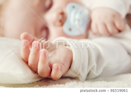 Cute five month old baby sleeping in comfortable bed. Cute five month old baby sleeping in comfortable bed. 98319061