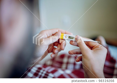 caucasian man staying in bed measuring temperature feeling sick 98319208