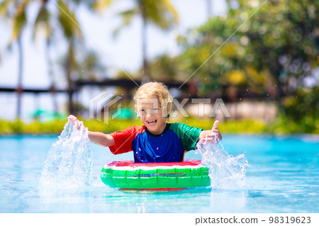Child in swimming pool on toy ring. Kids swim. 98319623