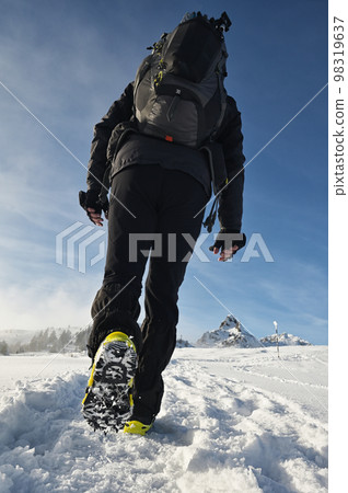 Man Walking On Snow With Shoe Spikes In Winter Man Walking On Snow With Shoe Spikes In Winter 98319637