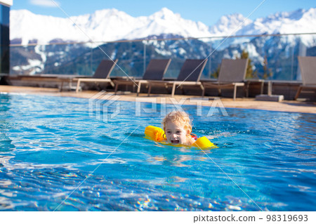 Child in outdoor swimming pool of alpine resort 98319693
