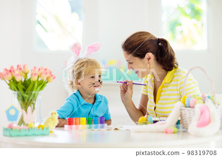 Mother and kids, family coloring Easter eggs. 98319708