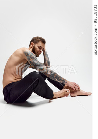 Stylish handsome young man posing shirtless. Textured muscular body shape. Tattoo body art. Concept of fashion, style, body aesthetics, beauty, men's health 98319733