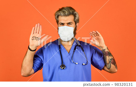 Open palm stop gesture. Epidemic threshold. Man in medical lab. Protective mask. Stop epidemic. Virus concept. Danger zone. Epidemic infection. Critical number or density of susceptible hosts Open palm stop gesture. Epidemic threshold. Man in medical lab. Protective mask. Stop epidemic. Virus concept. Danger zone. Epidemic infection. Critical number or density of susceptible hosts 98320131