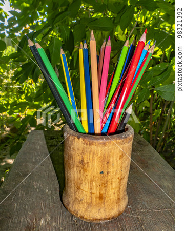 Colored pencils for drawing in a wooden glass. Colored pencils for drawing in a wooden glass. 98321392