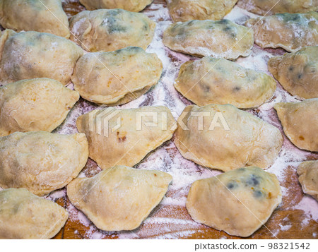 Ukrainian dumplings with dough stuffed on a cutting board. 98321542