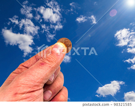 Hand with money coins on a background of blue sky. Hand with money coins on a background of blue sky. 98321585