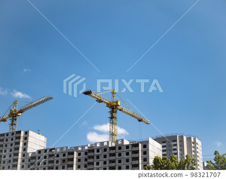 House construction with construction cranes on a background of blue sky. 98321707