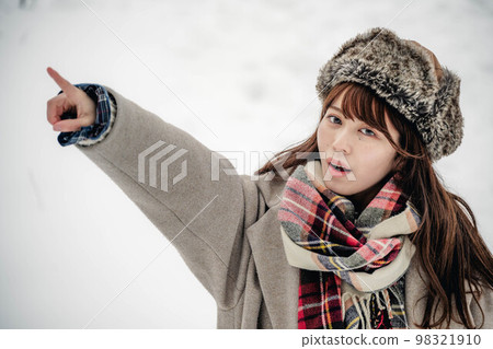 A woman enjoying wearing a checked scarf in the snow A woman enjoying wearing a checked scarf in the snow 98321910